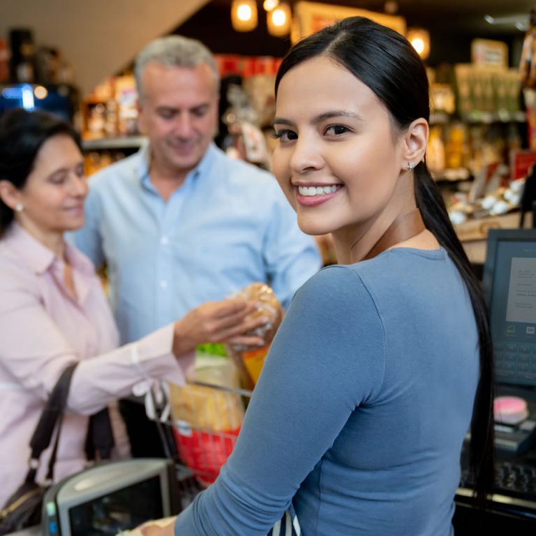 Retailer cashier helping customers at chekcout